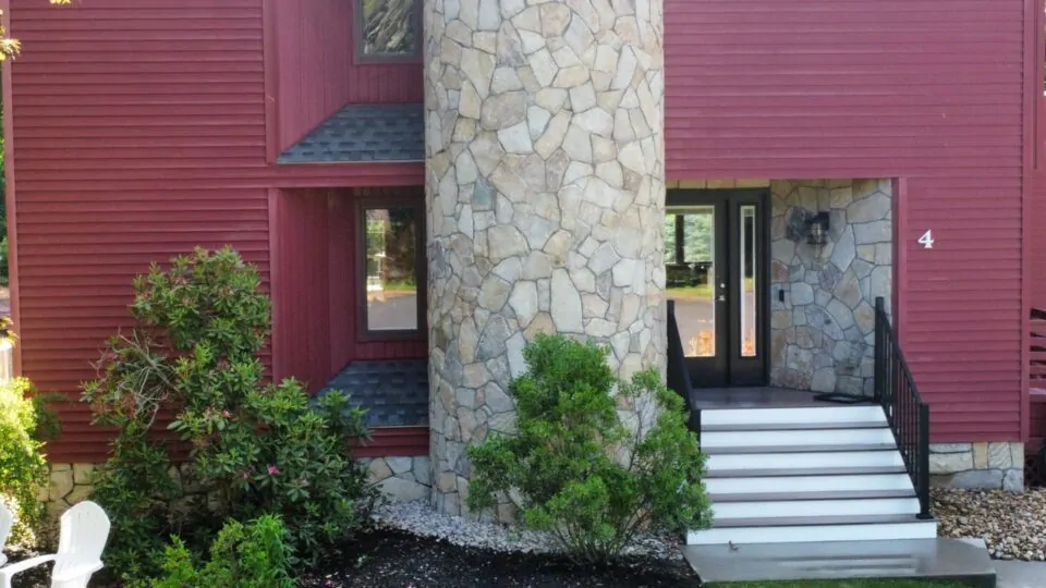 Outdoor living space with bluestone patio and stone fireplace built by JS Masonry